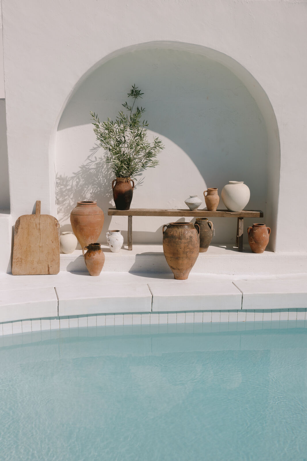 A white-plaster arch framing the pool at Caster House, a Santorini-style location in Los Angeles