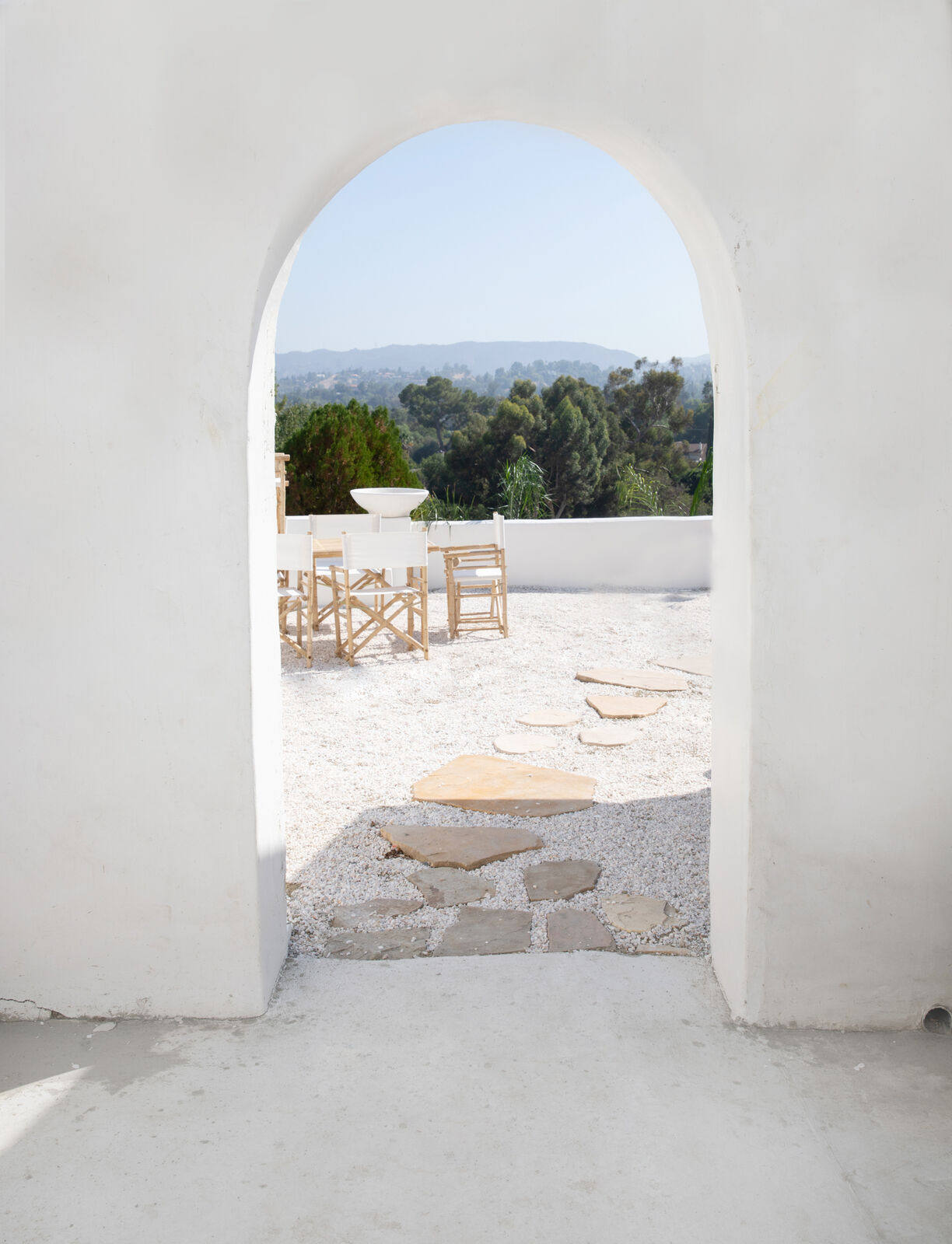 Arched courtyard view to the hills at Caster House, a whitewashed shoot location in Los Angeles