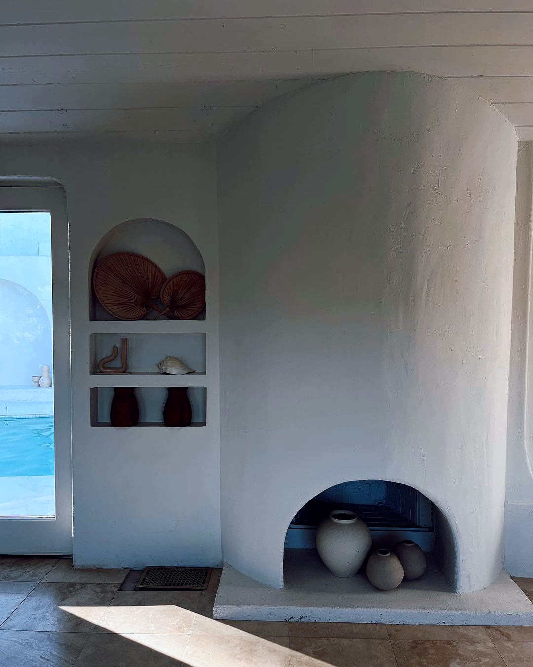 The sculptural white-plaster fireplace inside Caster House, a Mediterranean-style shoot location in Los Angeles