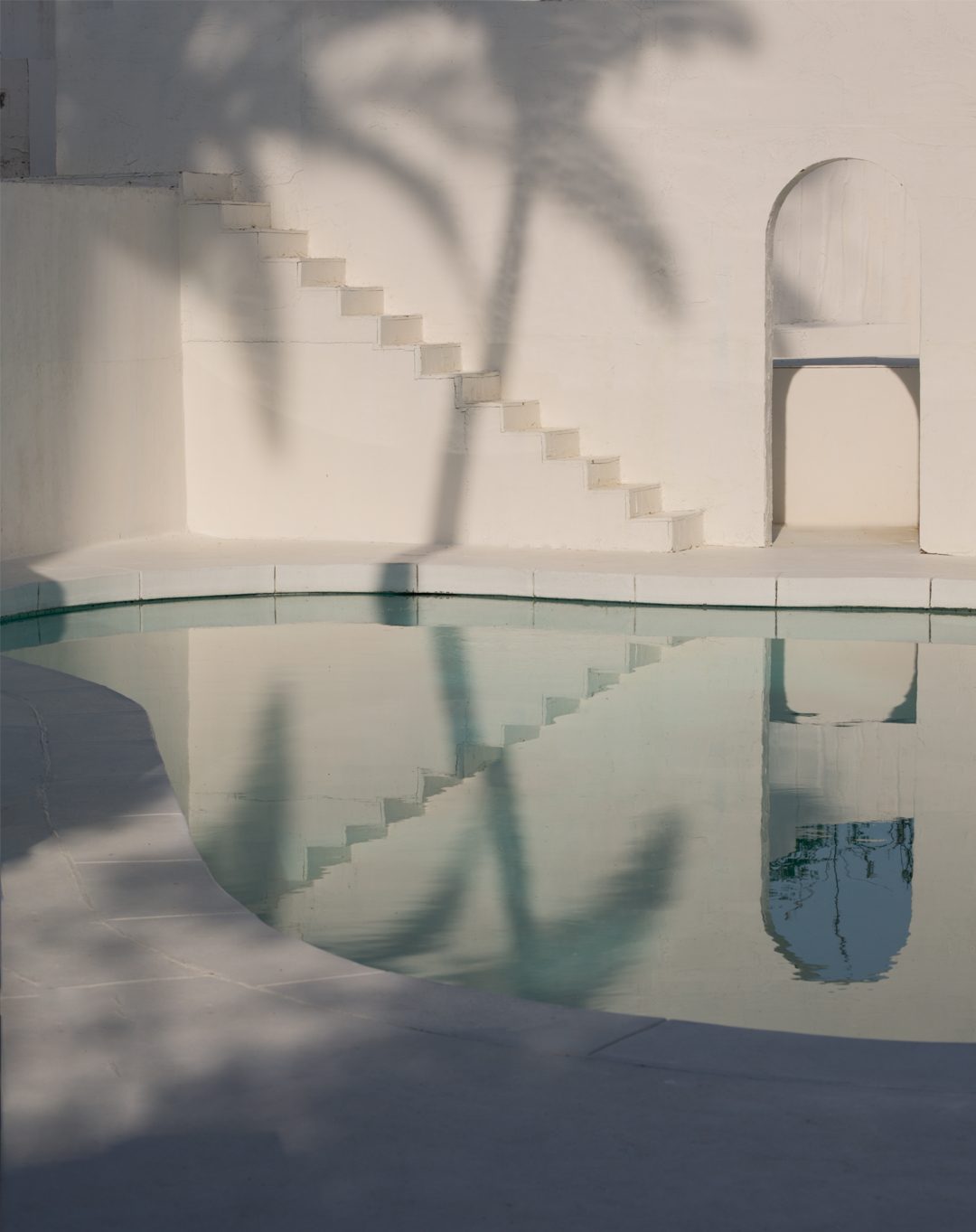 Golden hour by the white-plaster pool at Caster House, a Santorini-style shoot location in Los Angeles